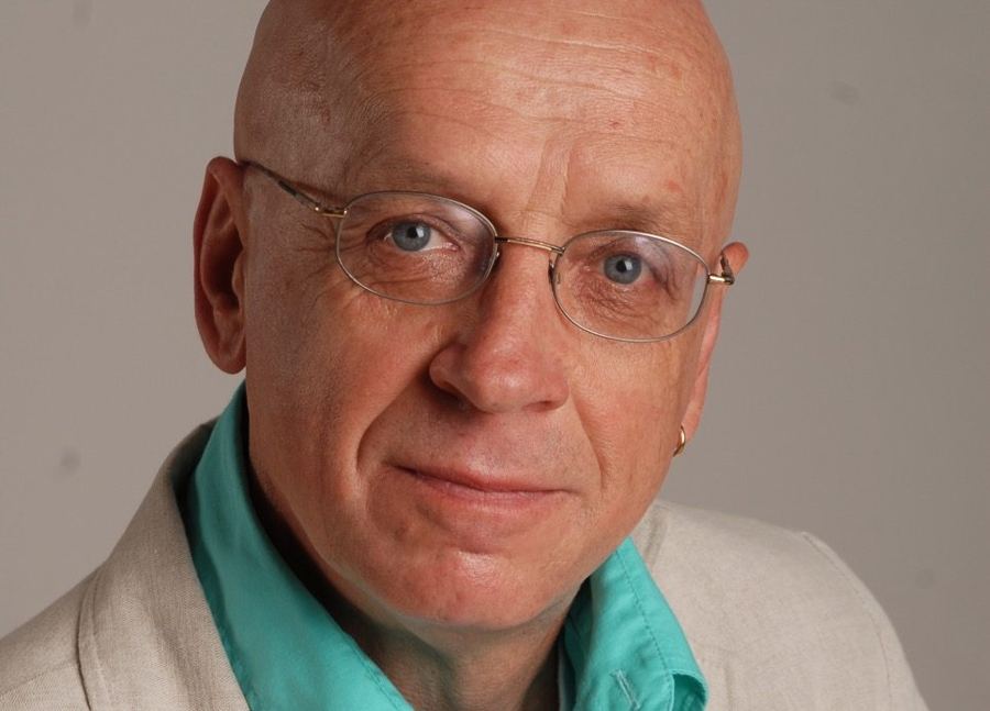 Porträt eines Mannes mit Brille und türkisfarbenem Hemd