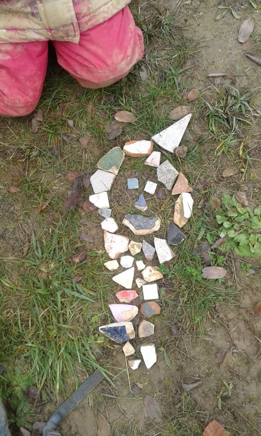 Mosaik aus bunten Porzellanscherben auf dem Waldboden gelegt